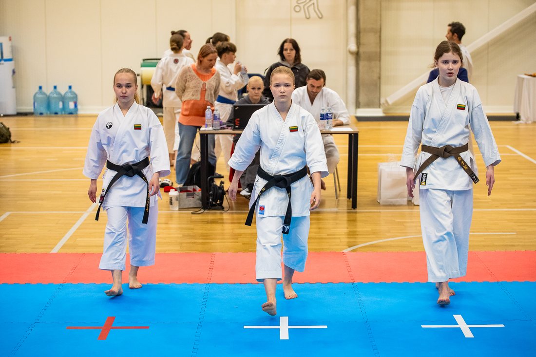 Sportininkės išeina į varžybų tatamį